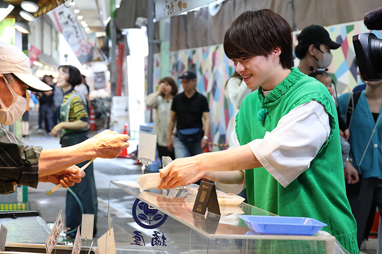 旦過市場のお店で、選んだ「お酒のアテ」をトレイに載せてもらう大橋さん。