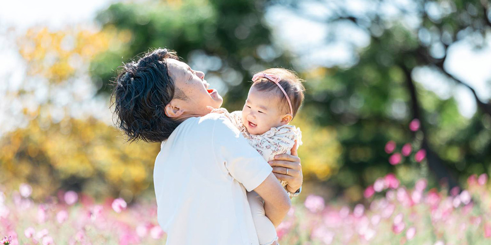 コスモス畑で娘を抱っこしている様子