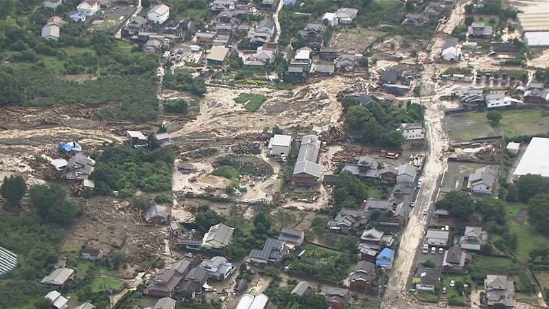 倒壊した家屋の傍で広域緊急援助隊が作業をする様子