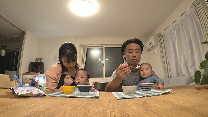 双子の赤ちゃんにご飯を食べさせているご夫婦