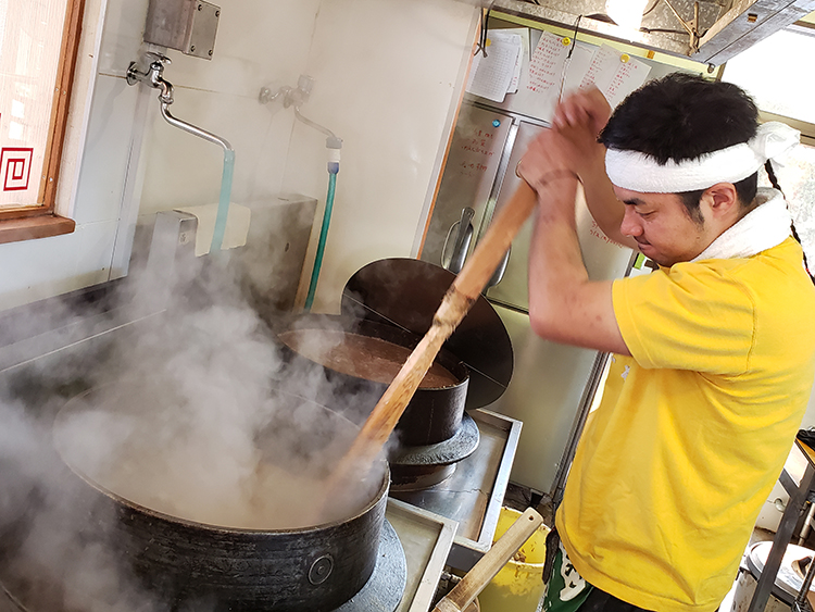 店主の北村和也さん。羽釜で炊く豚骨を混ぜ、旨味を絞り出す。 「“骨を炊き、カエシで味付けする”シンプルな豚骨ラーメンを追求したい」