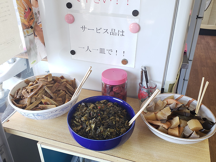 入口にお母さんの手作り総菜（無料）が並ぶ。特にキンピラゴボウが人気