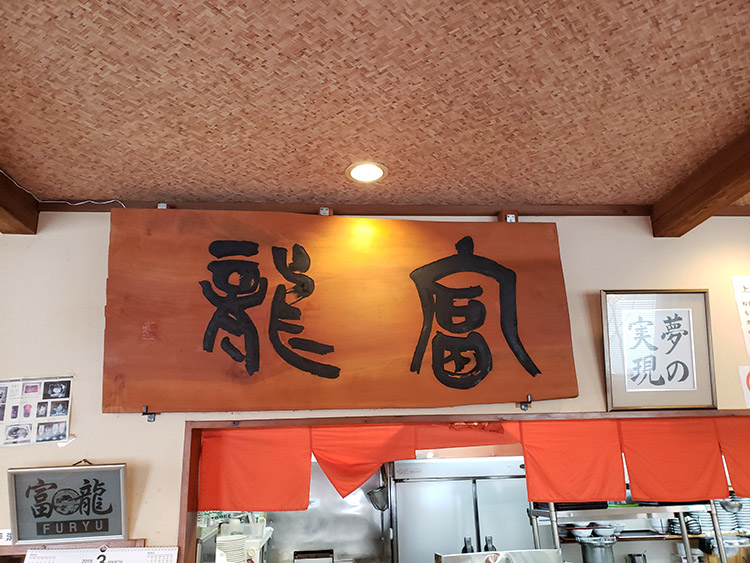 店内に大きな無垢板看板が掲げられる