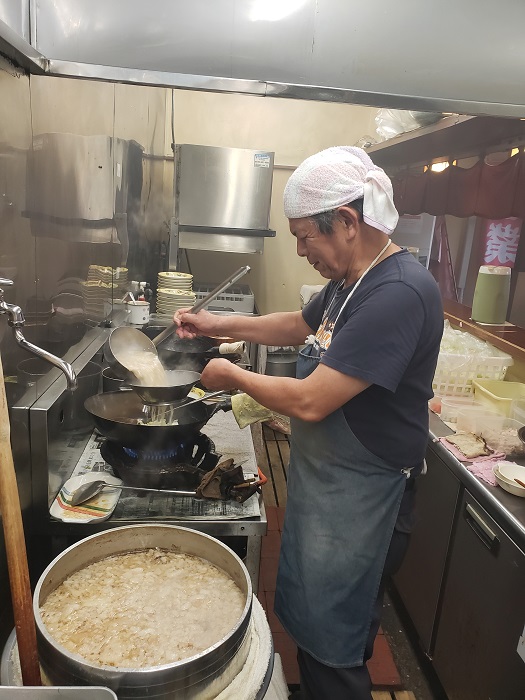 「一天愛」店主の岡田数広さん。手前に見える羽釜の豚骨×鶏ガラスープがラーメン、ちゃんぽんの基本になる