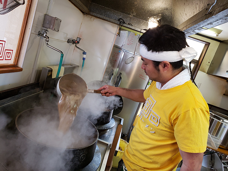 生骨を投入しながら煮込むスープは濃い茶色に。豚骨フレーバーが漂う