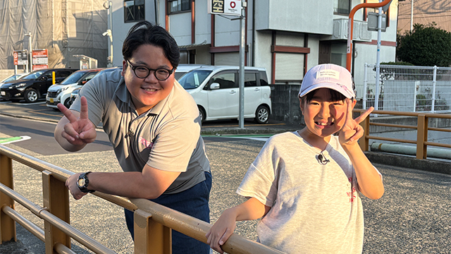 ピースするリポーター佐々木と子ども